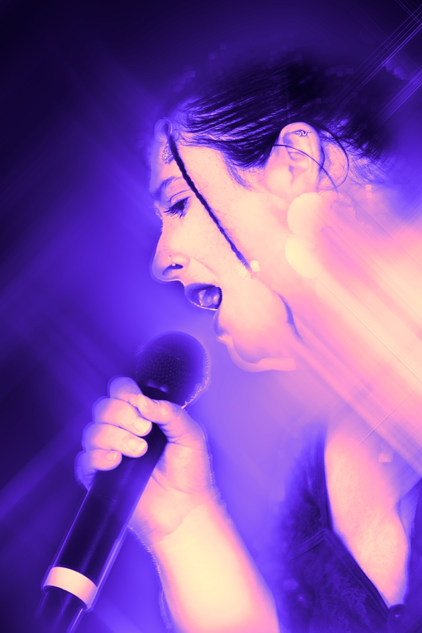 Rachele canta dal vivo immersa nella luce viola